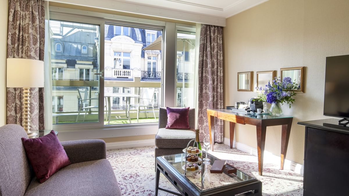 Purple cushions on a sofa by a glass table under mirrors in Executive Suite with Terrace at Warwick Paris Champs Elysées