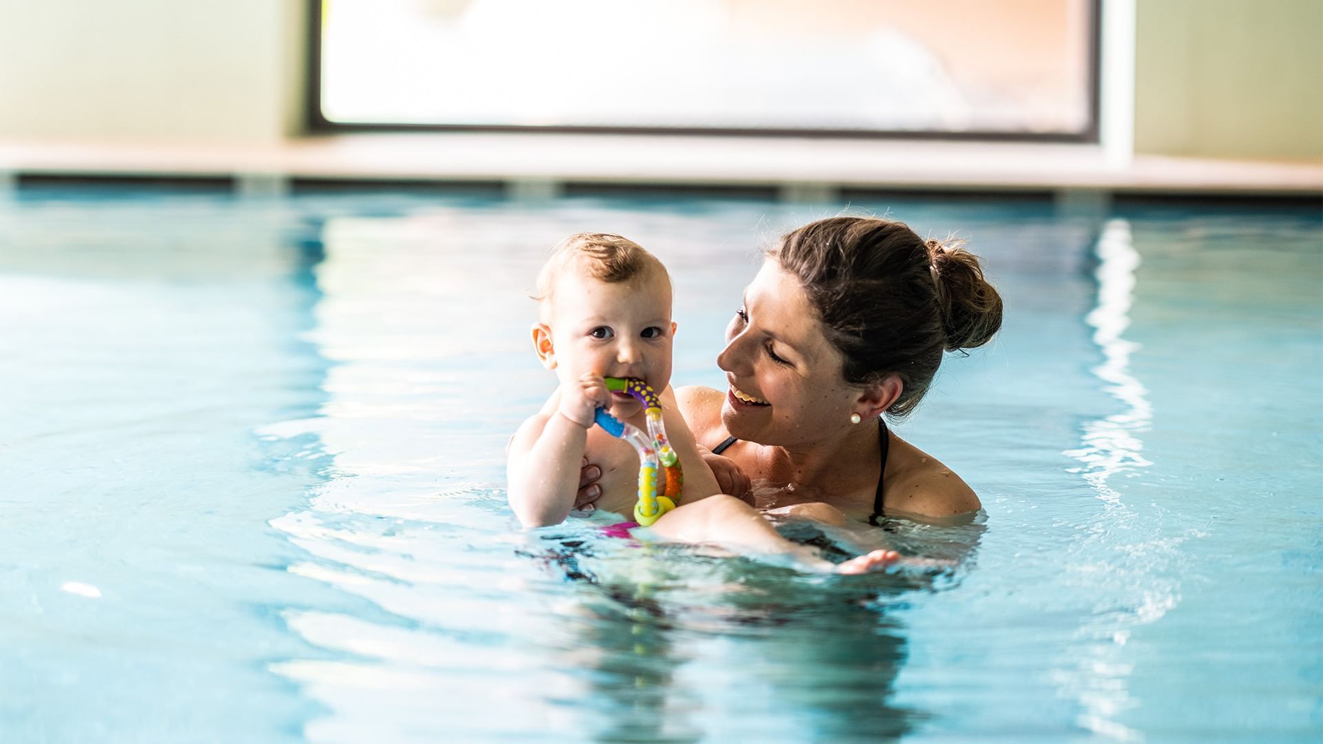 An adult and child in a swimming pool at Falkensteiner Hotel Montafon