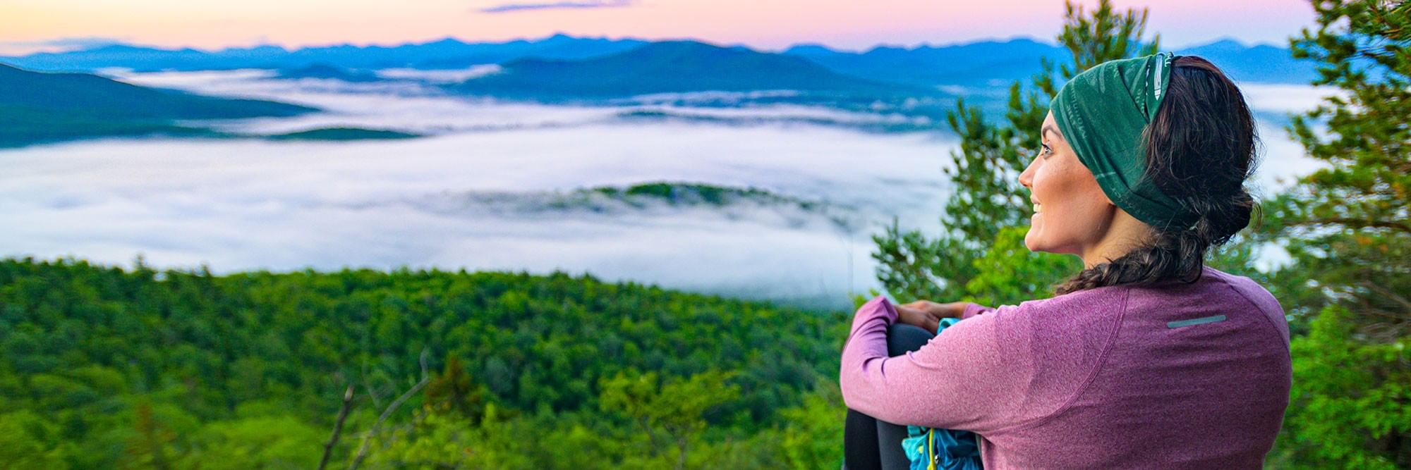 Women looking out over a cloudy mountain range.