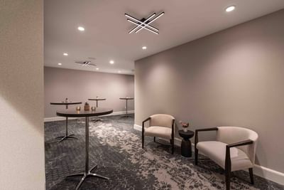 Waiting area with high-top tables and armchairs at Portland Harbor Hotel