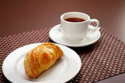 Cup of tea & Curry Puff served on a woven mat at York Hotel Singapore