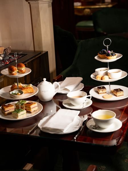 Afternoon tea service with tiered stands of pastries, sandwiches, and teacups at Hôtel Westminster in Paris
