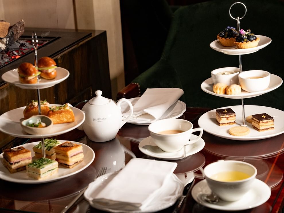 Afternoon tea service with tiered stands of pastries, sandwiches, and teacups at Hôtel Westminster in Paris