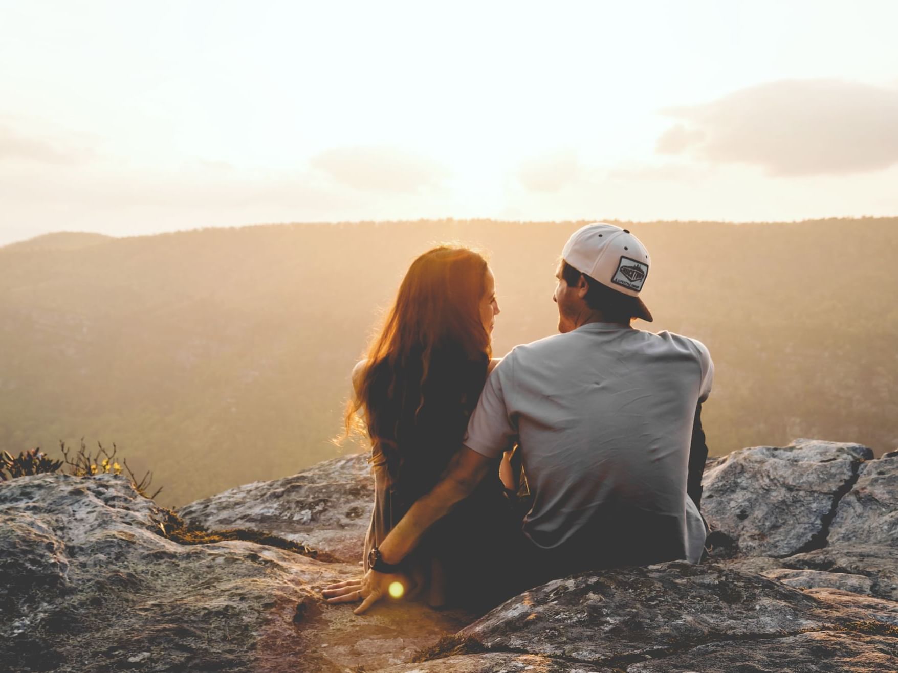 A couple sitting on a rock near Hotel Cumbres San Pedro