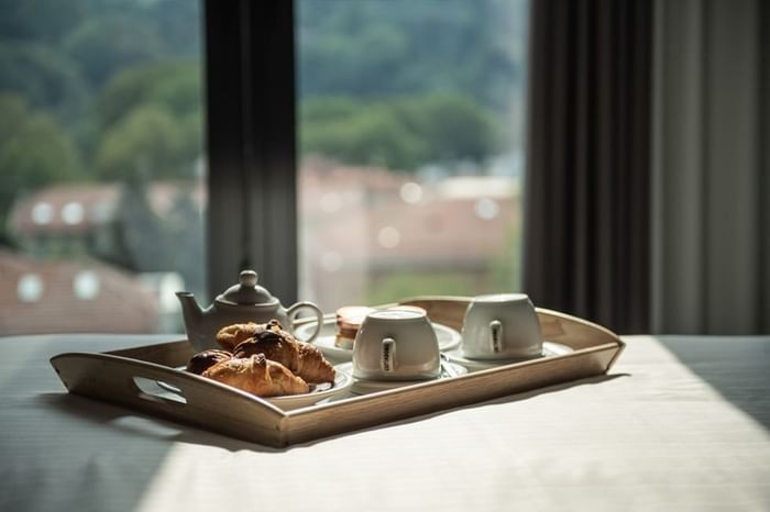 Colazione su un vassoio di legno in una camera con vista su Duparc Contemporary Suites