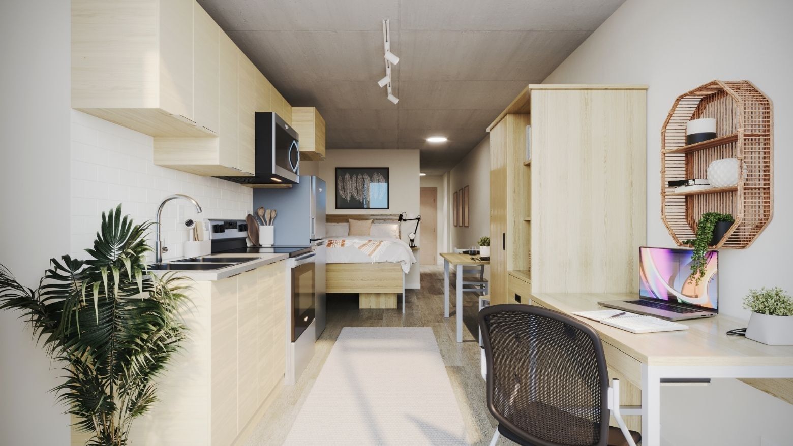 A large and modern studio apartment with full in-suite amenities, including a desk, a  desk chair, a kitchen, a dresser, a kitchen table, and a bed with under-bed storage.