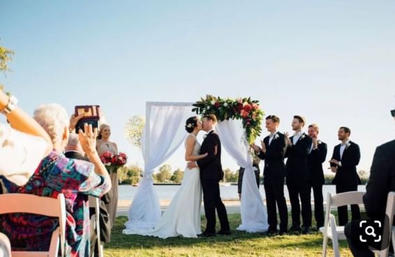 Bride and groom kissing at a wedding outdoors in Northshore Cafe at Alcyone Hotel Residences