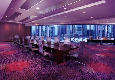 Fania Meeting Rooms 1 - 6 with chairs placed by a long wooden table under purple lighting at Megapolis Hotel Panama