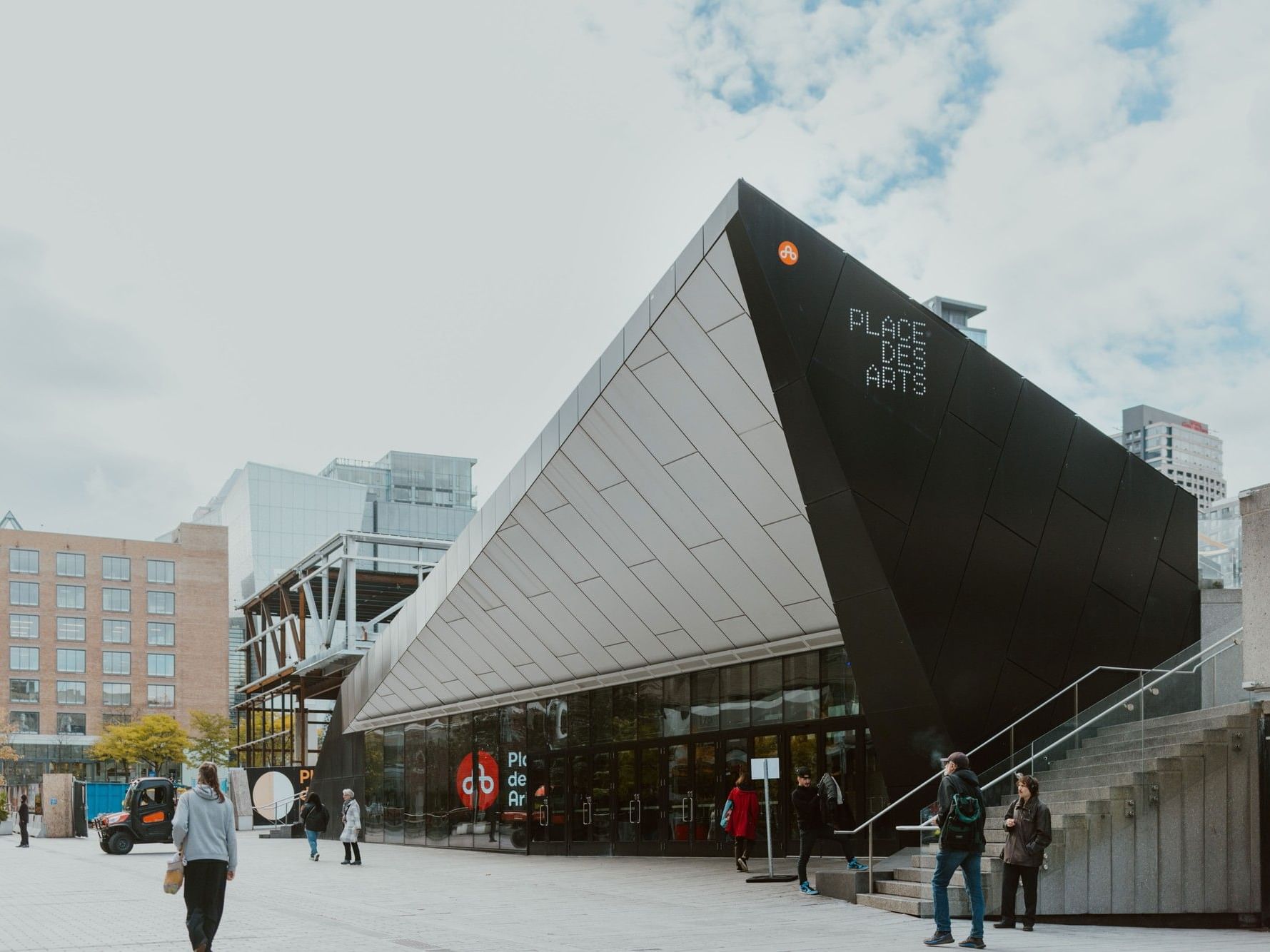 Place des Arts avec des piétons et des bâtiments modernes.