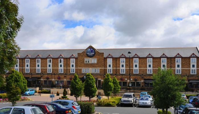 An exterior view of the hotel & car park at Village Hotels