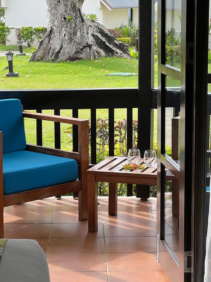 Wooden chair and side table on the porch of a garden bungalow at Warwick Le Lagon - Vanuatu, Efate.