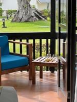 Wooden chair and side table on the porch of a garden bungalow at Warwick Le Lagon - Vanuatu, Efate.