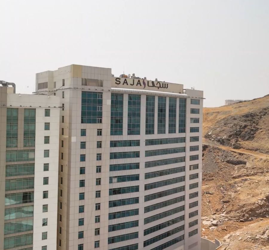 Exterior view of the high-rise Saja Hotels building against a rocky desert landscape