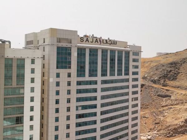 Saja by Warwick Makkah hotel building exterior with many windows and a desert landscape.