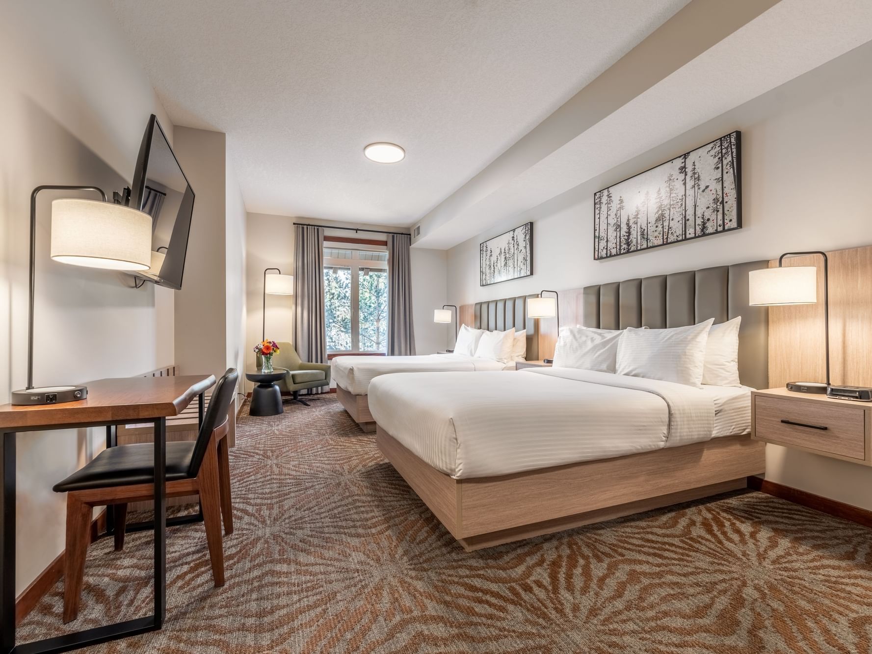 Two queen beds, a work desk, and a TV in the Deluxe Room at Blackstone Mountain Lodge