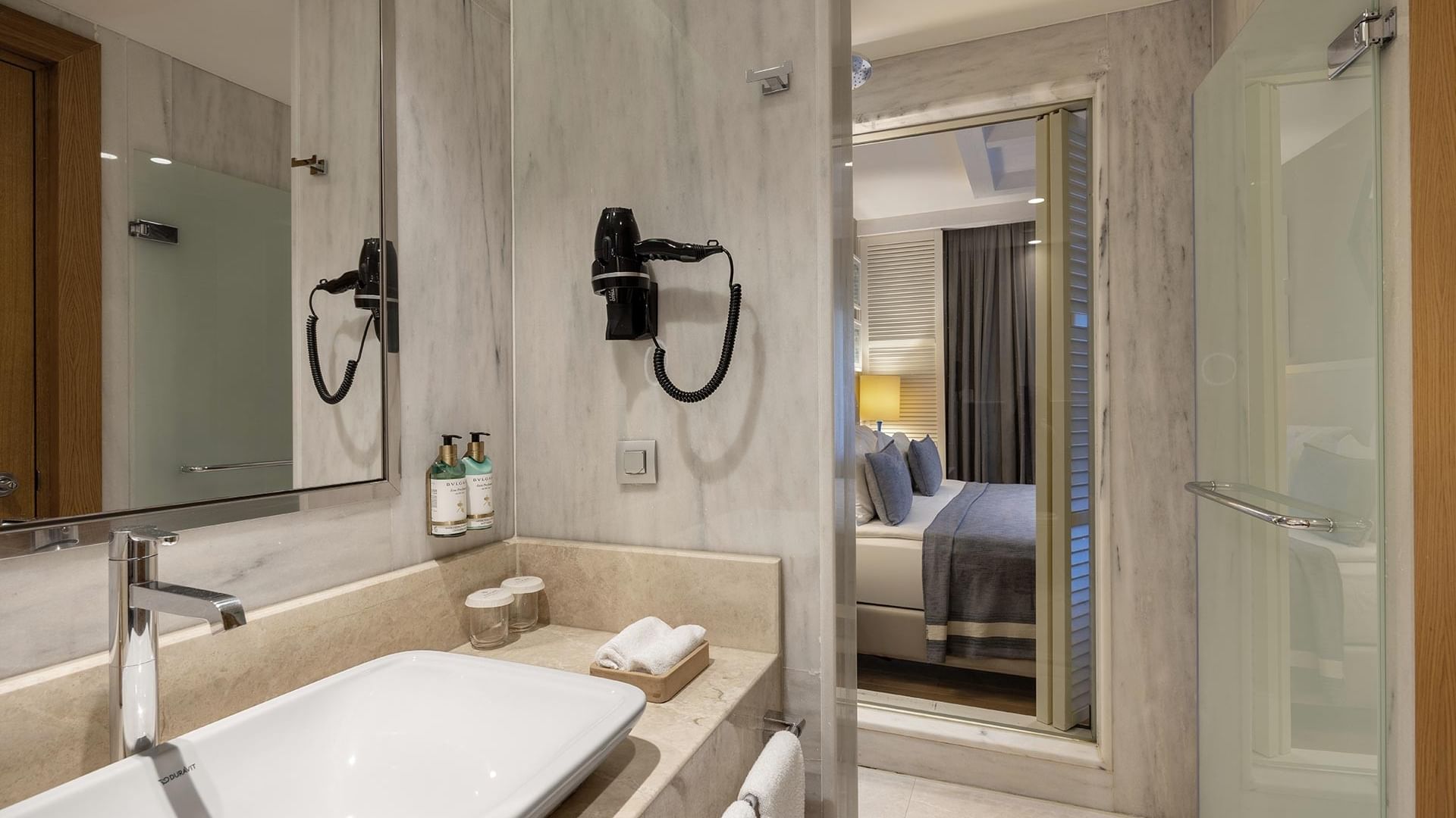 Titanic Luxury Collection Bodrum’da geniş lavabolu, aynalı ve duşlu Family Suite banyosu.