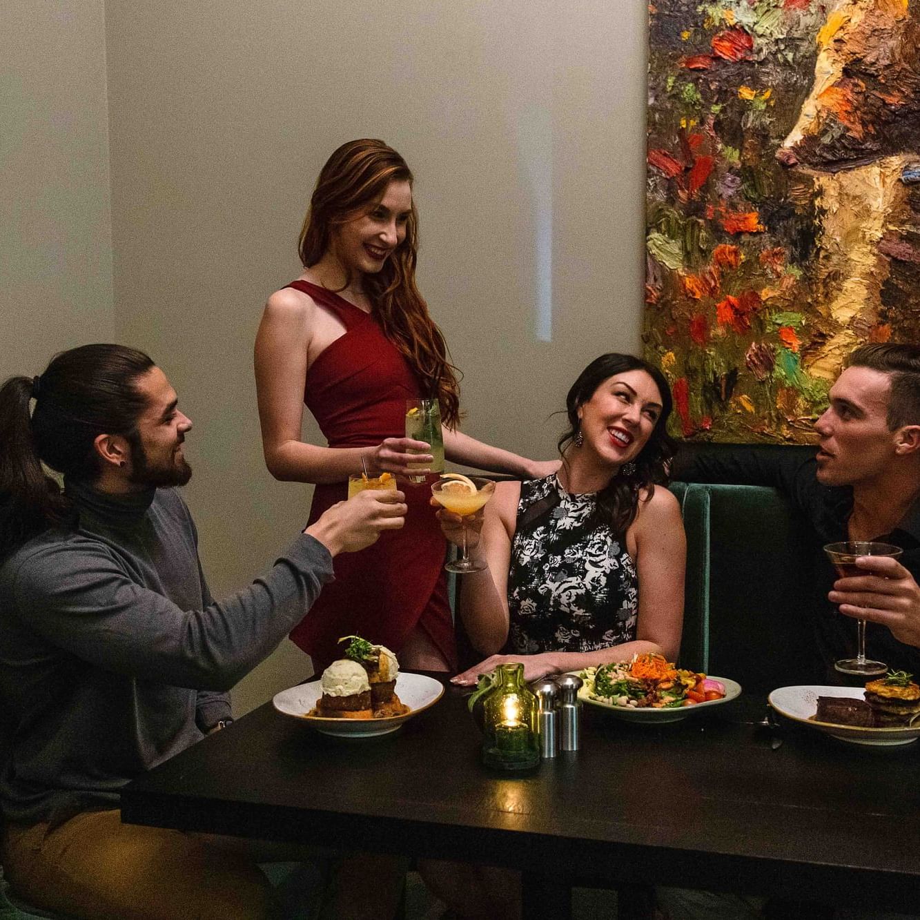 Four people dining in table with food and drinks at Hotel 43