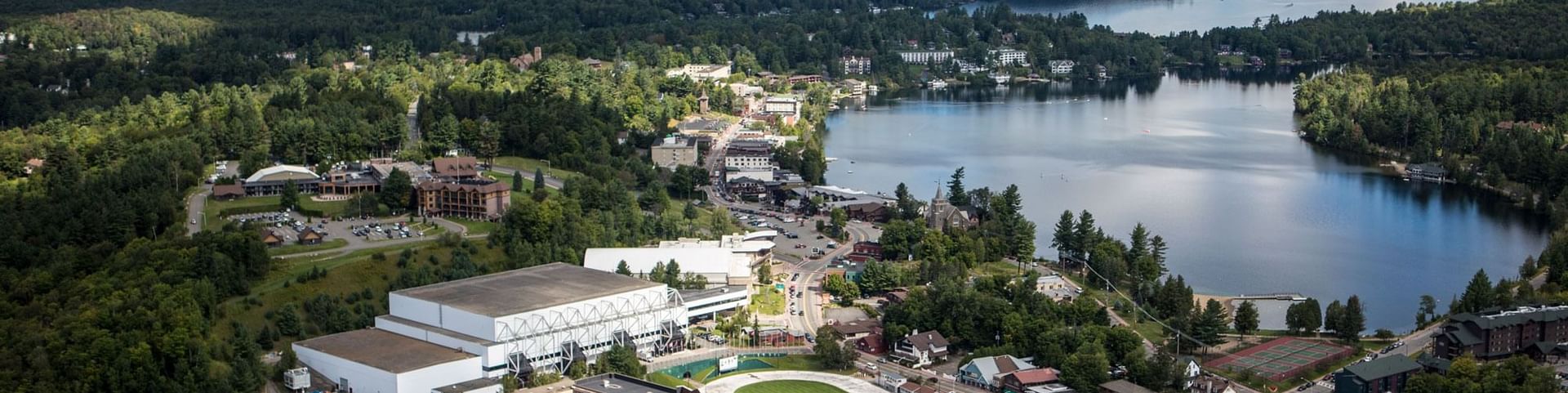 Aerial view of the village, Lake Placid, and surrounding mountains, showcasing the resort of High Peaks Resort