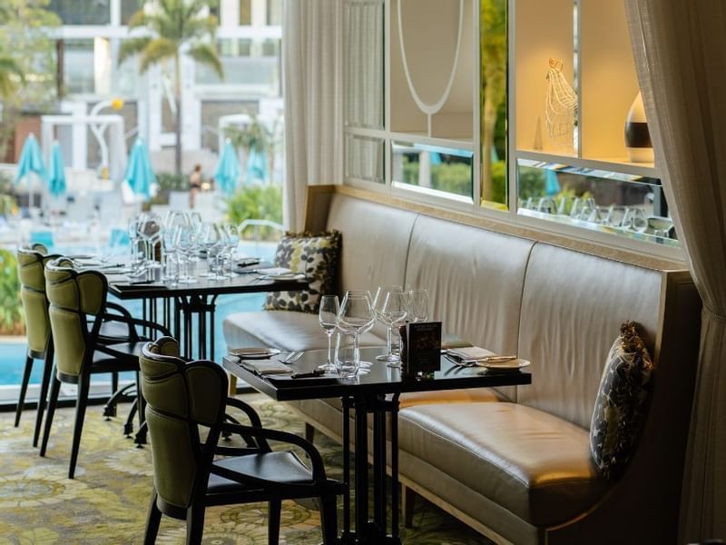 Indoor restaurant with set tables and a view of poolside in Bistro Guillaume at Crown Metropol Perth