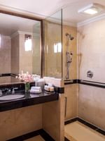 Granite vanity & inset sink, below framed mirror in tiled bathroom in Accessible On the Avenue Suite at Warwick New York