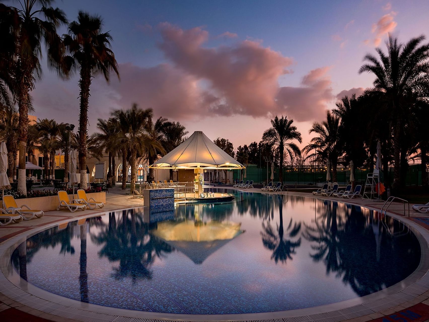 Outdoor swimming pool with sunbeds at Metropolitan Al Mafraq Hotel