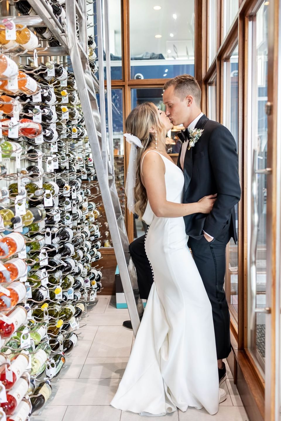 Newlywed couple shares a kiss in the wine cellar at our Avalon wedding venue