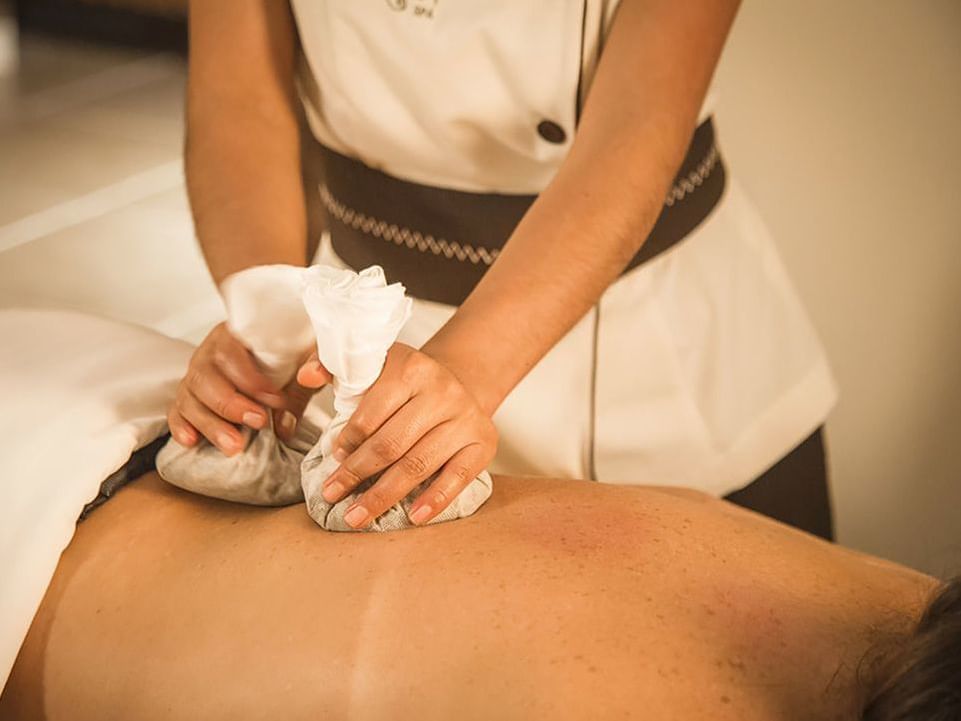 A masseuse treating a client in Aqlla Spa at Hotel Sumaq