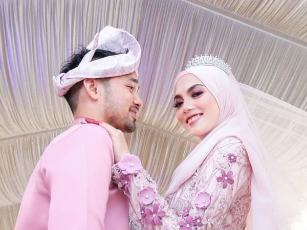 Bride & groom in pink wedding attire posing for a photo at Hotel Maya Kuala Lumpur City Centre