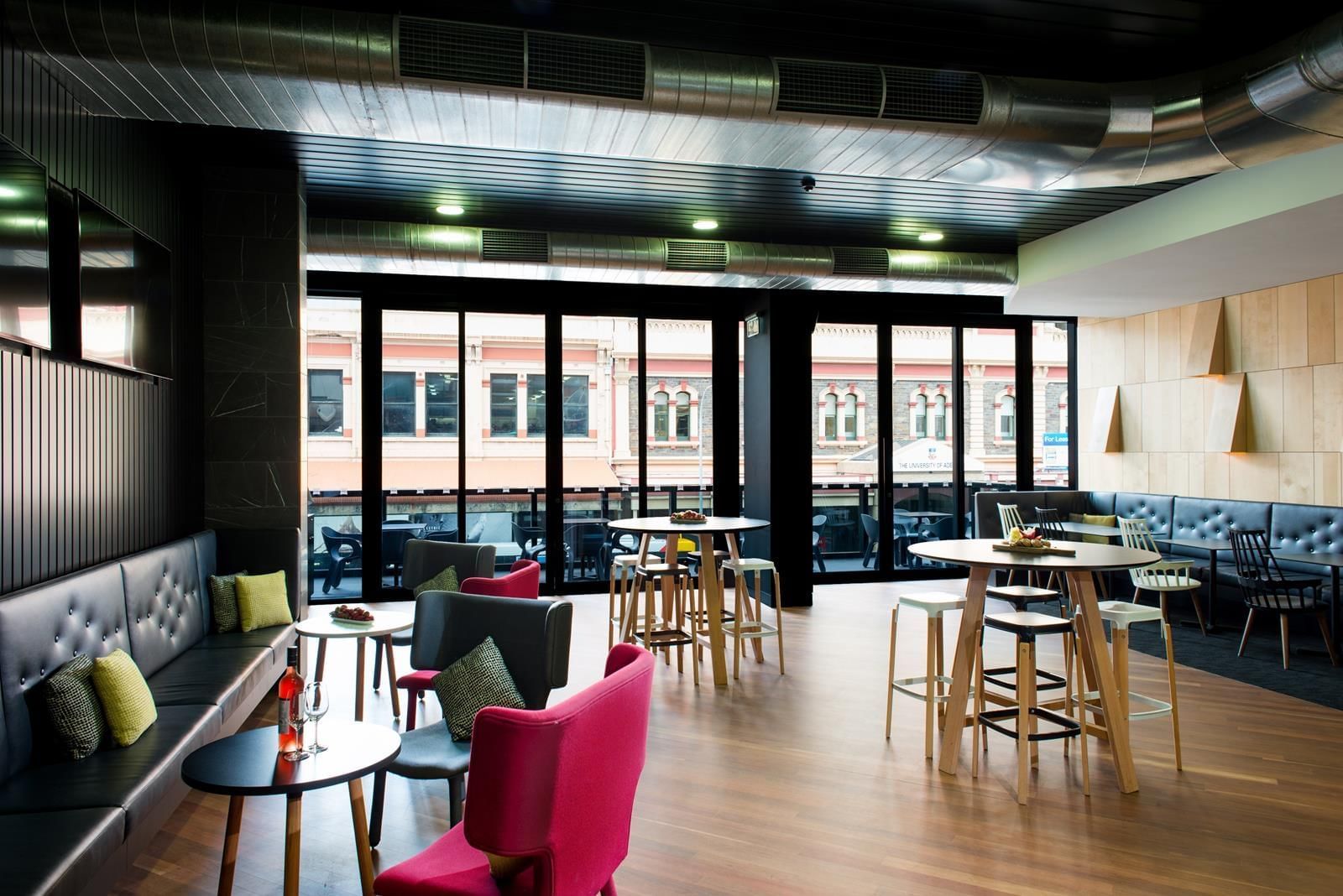 Level One Bar featuring modern seating, high tables, and windows leading to a balcony with city views at Ibis Adelaide