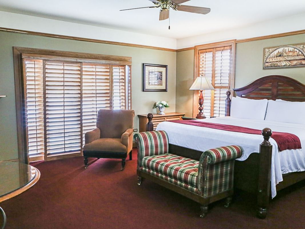 a bed, chair, and table in a hotel room