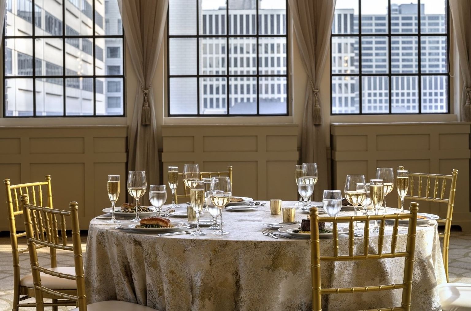 Elegantly set dining table with cityscape view through large windows at Warwick Allerton Chicago