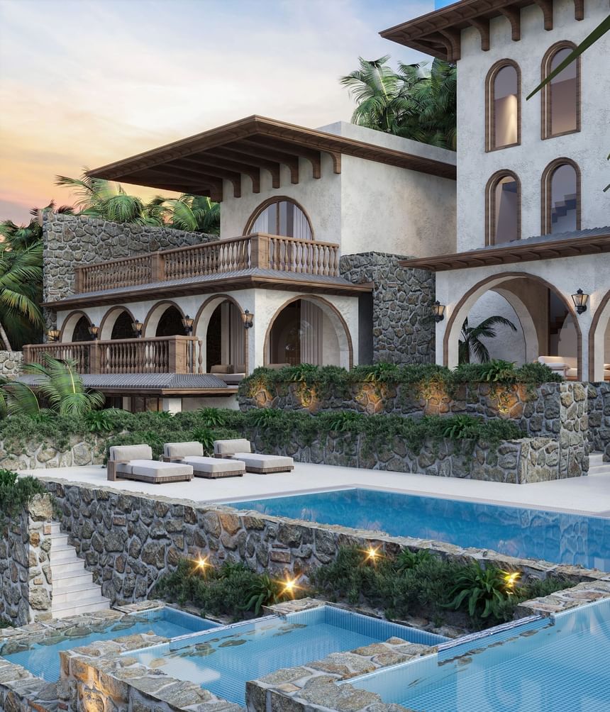 Grand multi-level Mediterranean Sogno Villa with a terraced patio, stone walls, and outdoor pool area at A'ila Villas