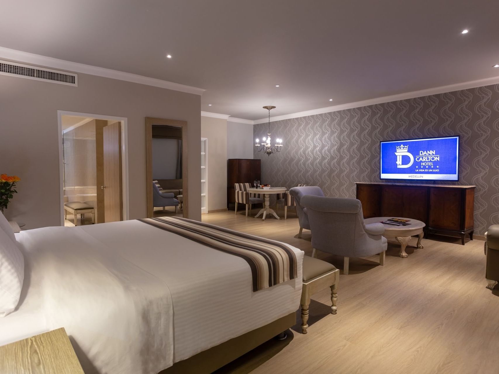 Modern decor with cozy bed, TV and sitting area in Grand Suite Real at Hotel Dann Carlton Medellin