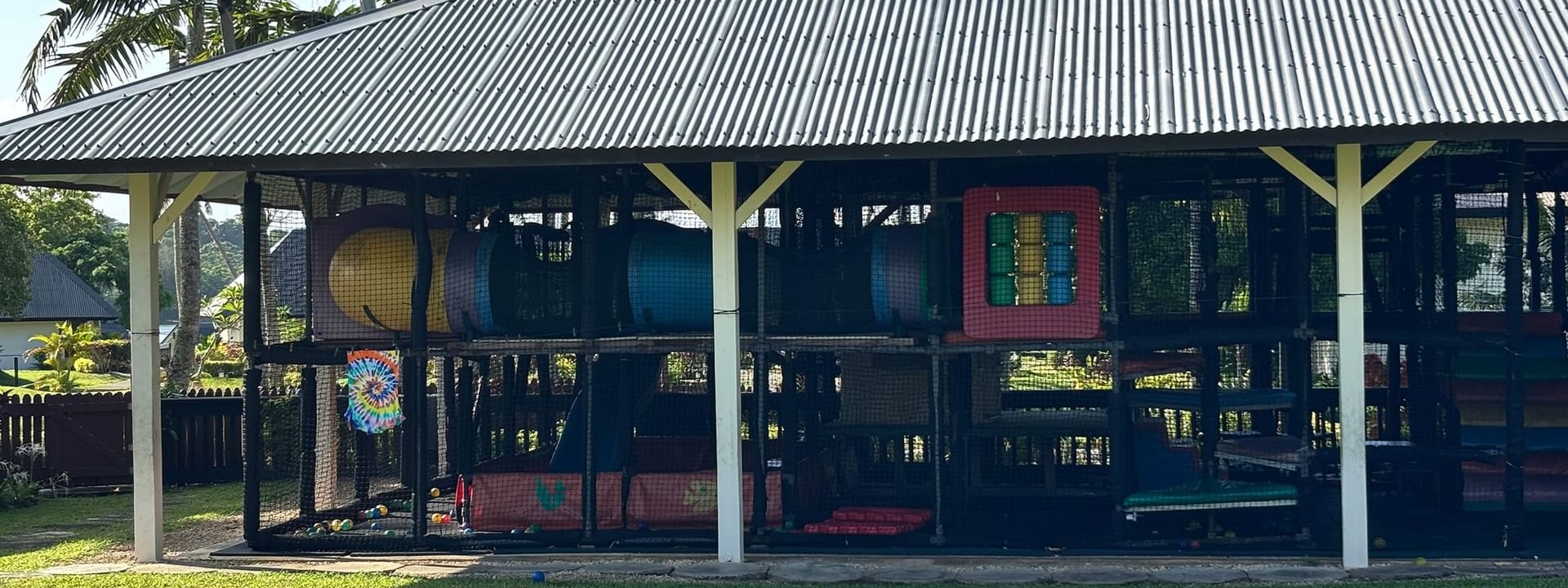 Enclosed playground with colorful equipment and metal roof at Warwick Le Lagon - Vanuatu, Efate