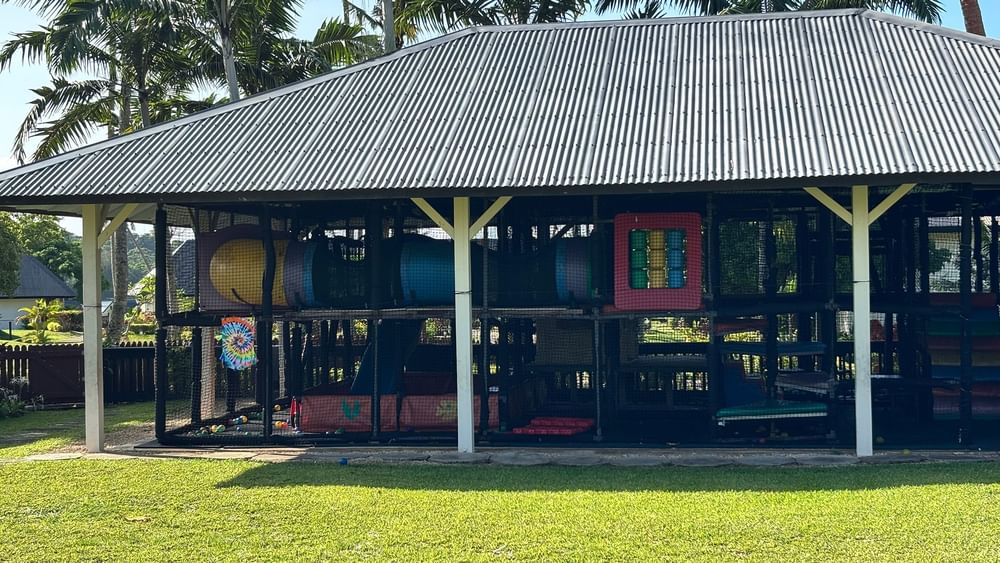 Enclosed playground with colorful equipment and metal roof at Warwick Le Lagon - Vanuatu, Efate.