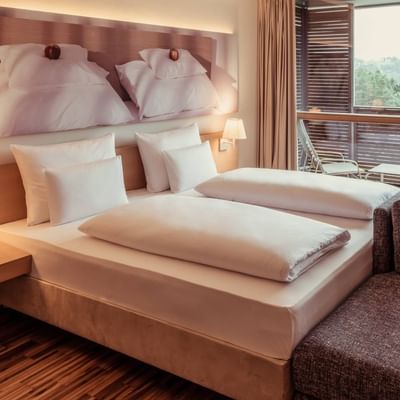 Deluxe room, Bed with comfy sheets at Falkensteiner Hotels