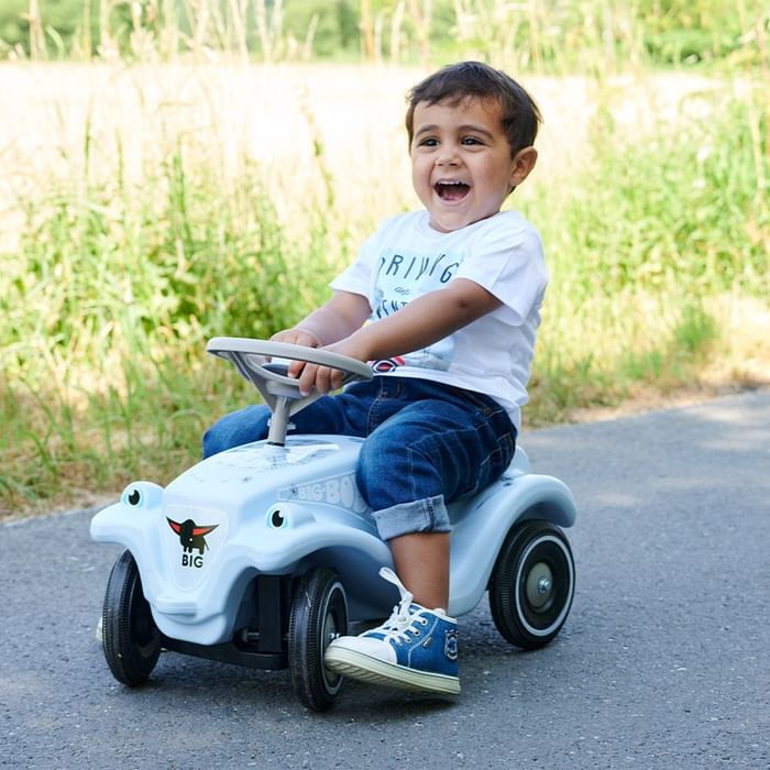 Child riding a toy car on a path near Falkensteiner Hotel Montafon