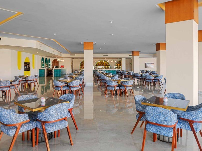 Elegant dining area with blue chairs and wooden tables at Pickalbatros Aqua Blu Resort in South Sinai Governorate.