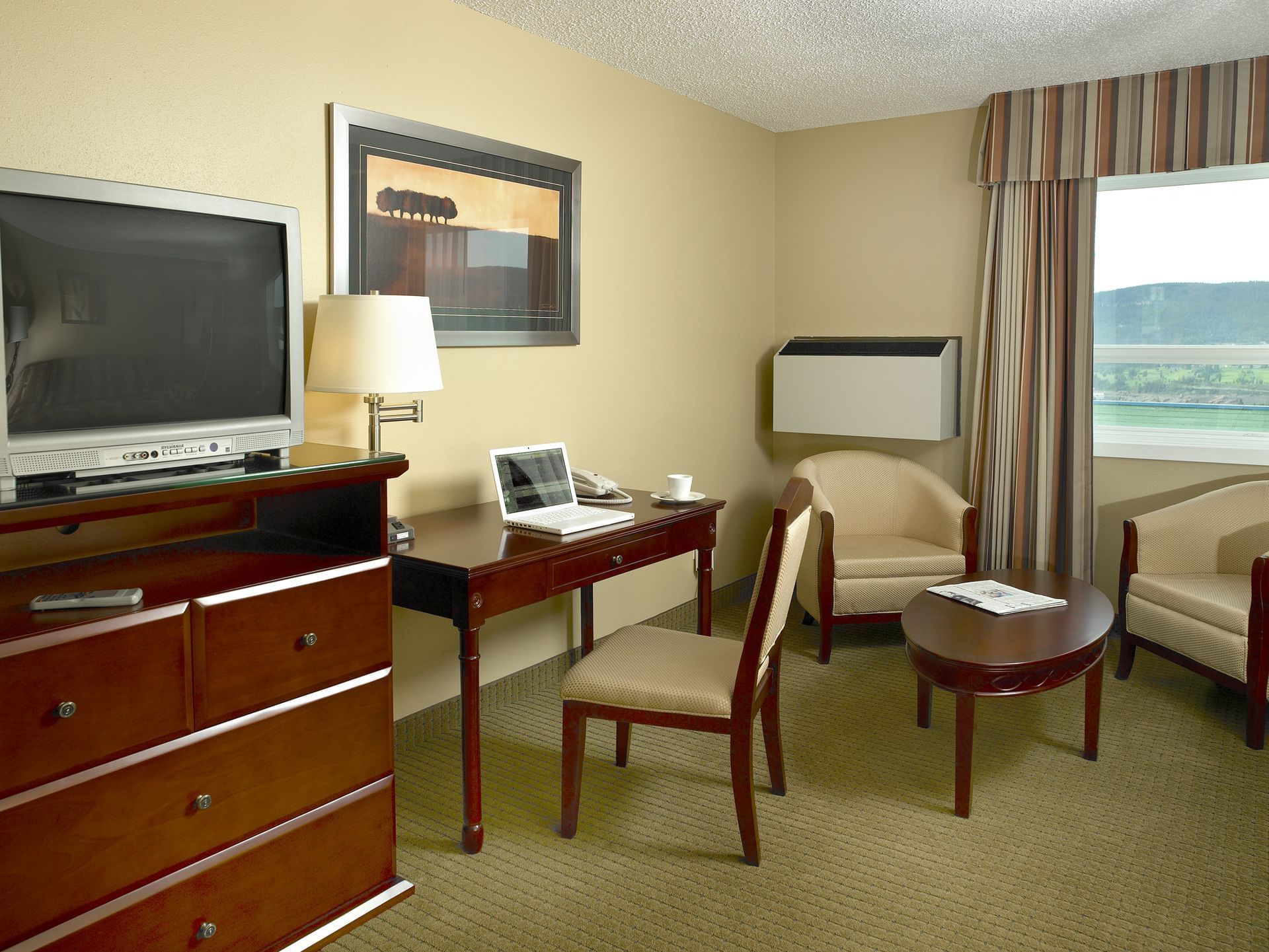 TV and desk in hotel room with window