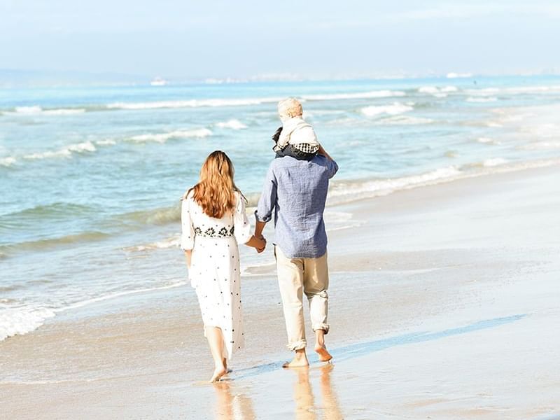 A family walking on the beach near Amatara Wellness Resort
