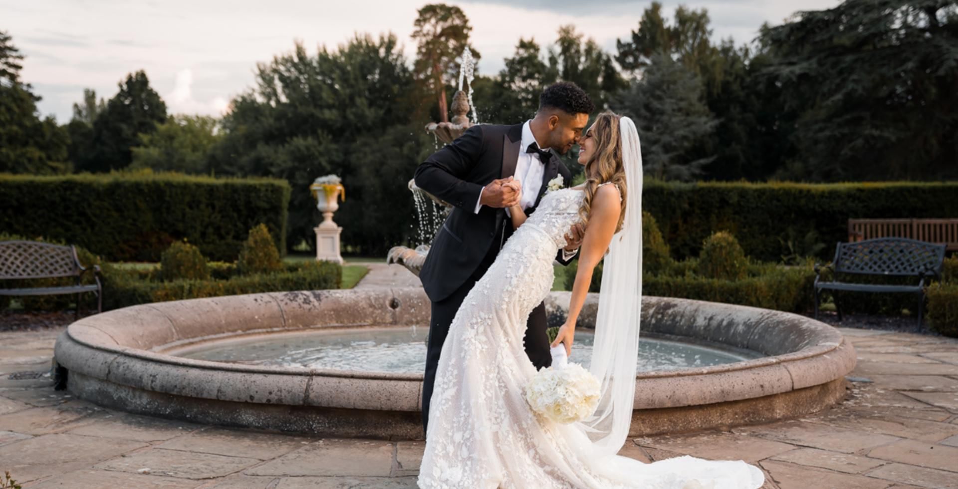 Bride and groom by the iconic fountain at Easthampstead Park
