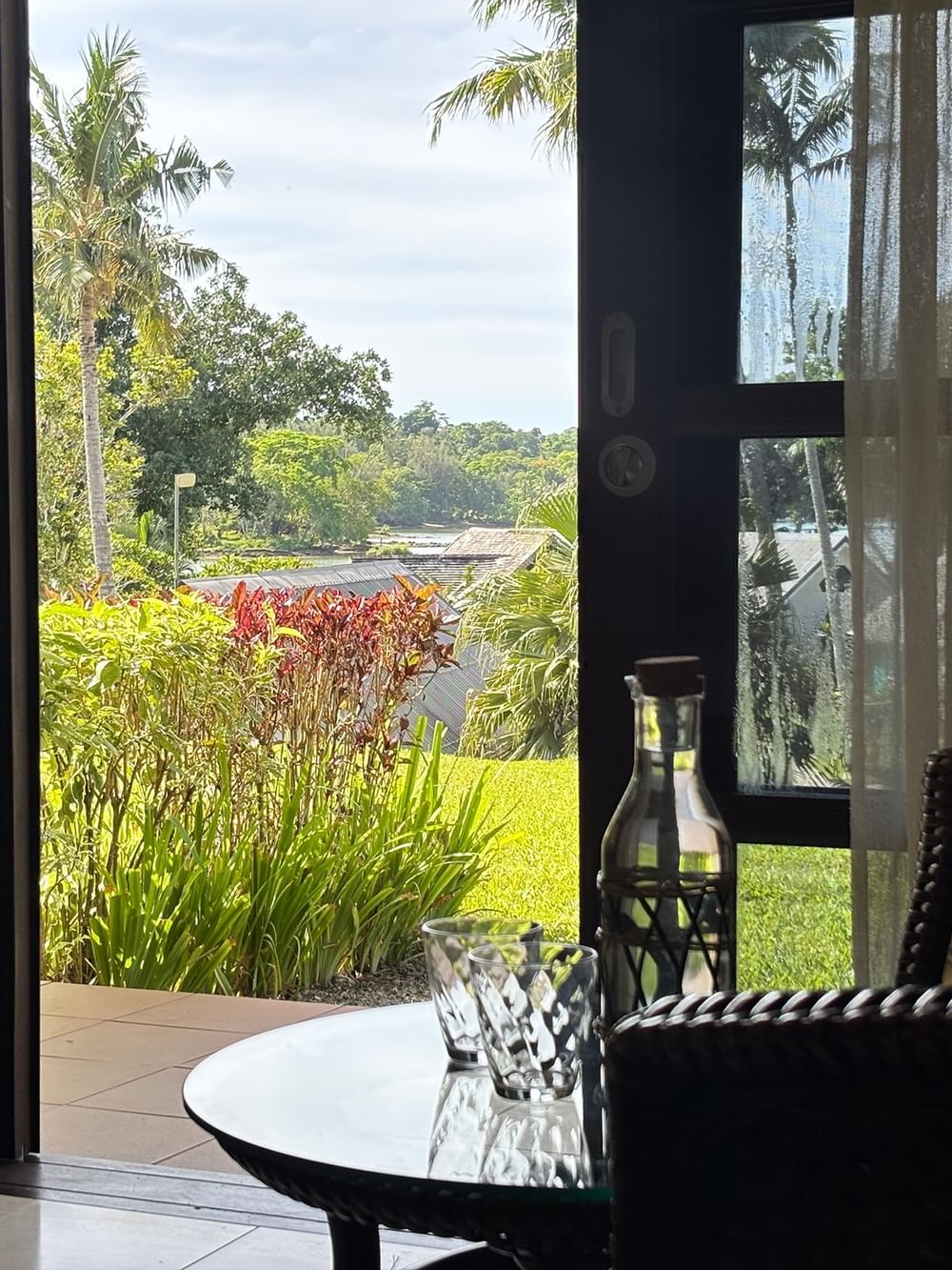 Opened doors show a garden view room at Warwick Le Lagon - Vanuatu in Efate.