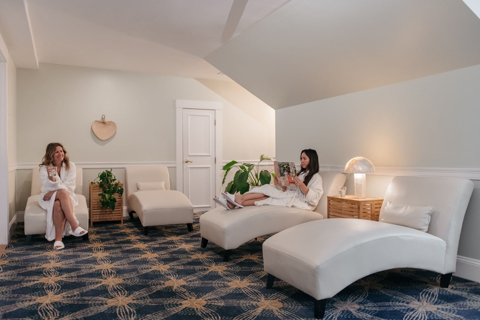 Two women in white bathrobes relaxing on lounge chairs in a spa at Mountain View Grand Resort & Spa