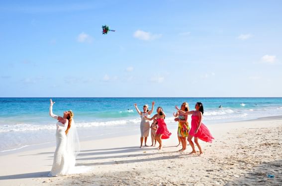 Bride tossing the bouquet on the beach at Bougainvillea Resort