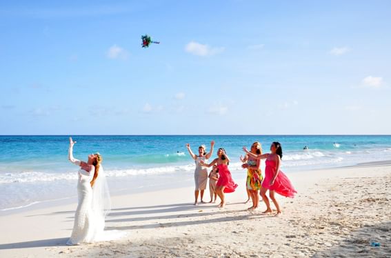 Bride tossing a bouquet by the sea near Bougainvillea Barbados