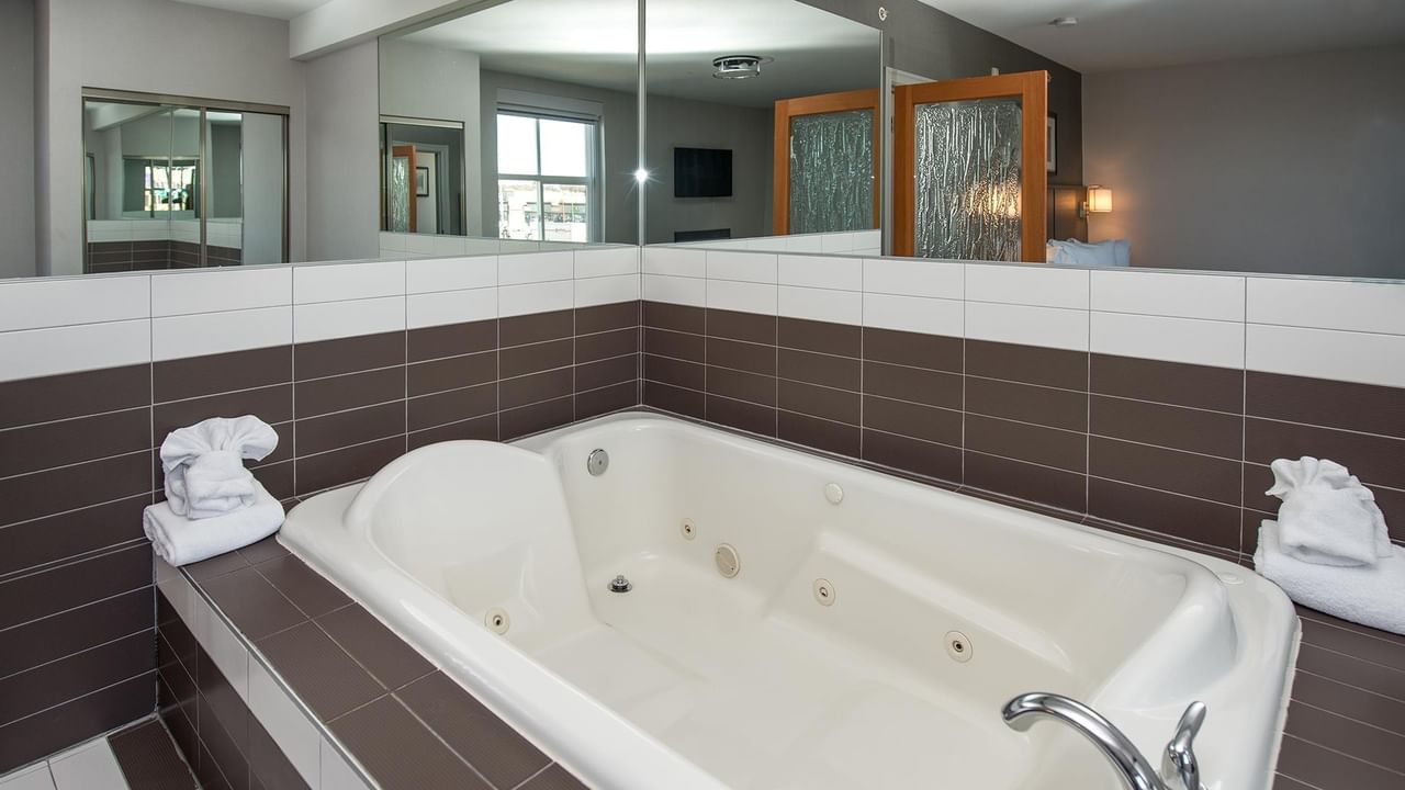 Large jetted tub with towels in a hotel room.