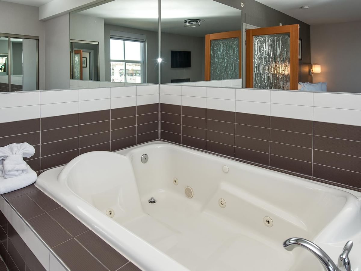 Large jetted tub with towels in a hotel suite.