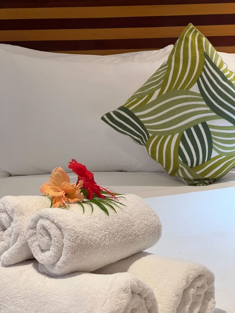 Towels and flowers on a bed in Warwick Deluxe Rooms at Warwick Fiji Resort and Spa, Korolevu.