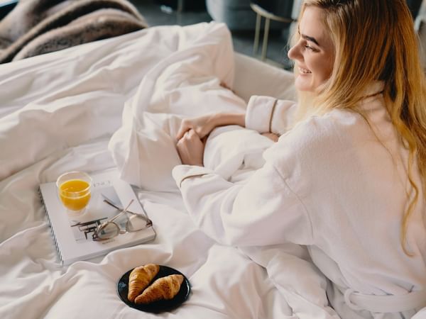 Kvinna som kopplar av under en lyxig hotellvistelse på Hotel Riverton i Göteborg.