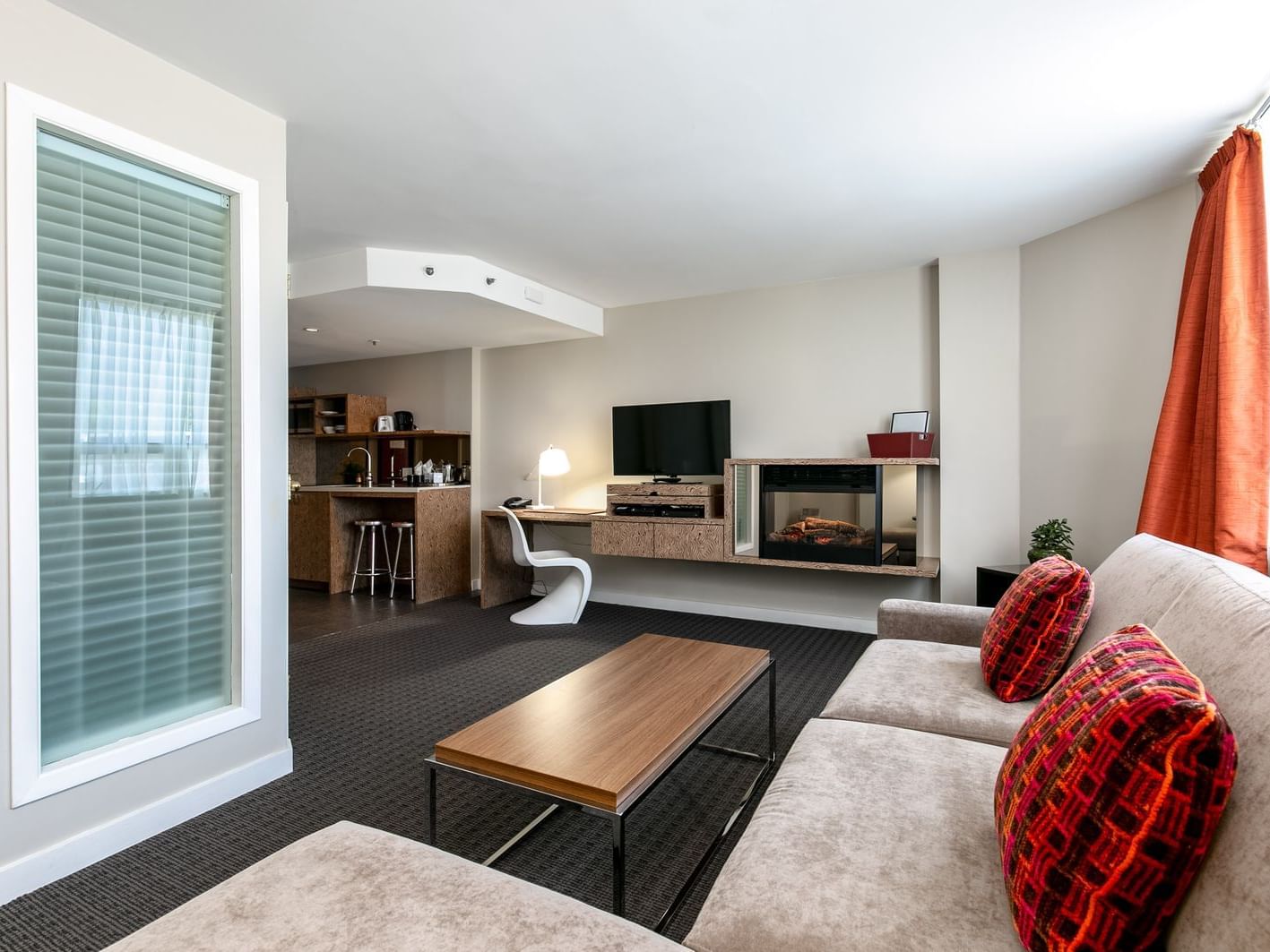 Broad living space in hotel room with kitchenette.